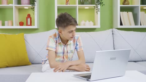 Niño-Usando-Una-Computadora-Portátil-Escondido-De-La-Familia.